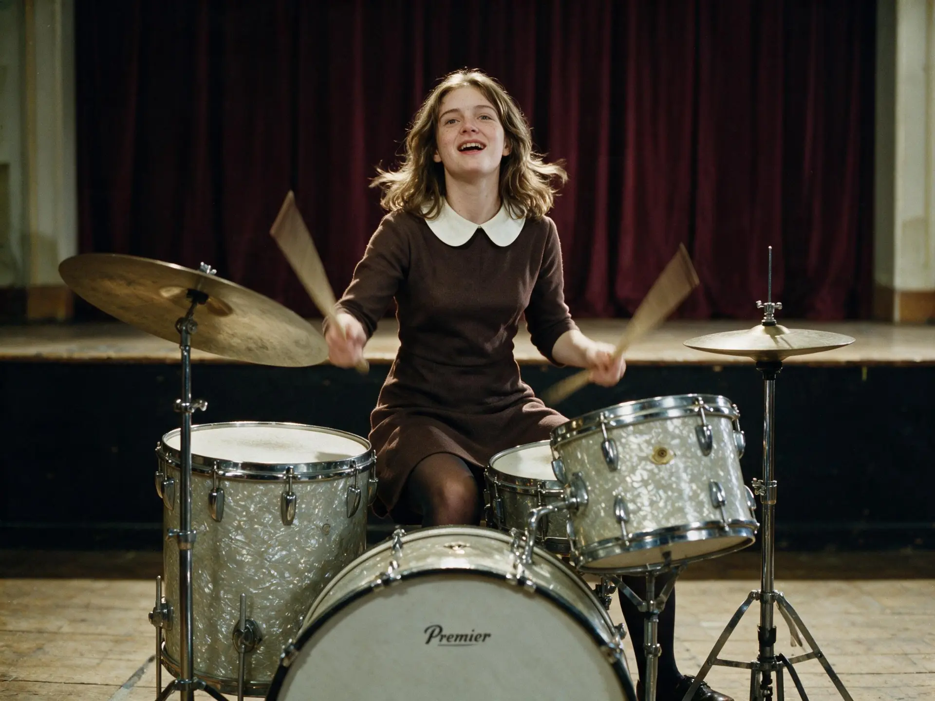 Rosie Pilbeam playing a Premier drum kit on a village hall stage